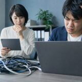 パソコンが遅い原因と会社でできる改善方法の内容を表す、中小企業の担当者がIT課題を整理しているイメージ